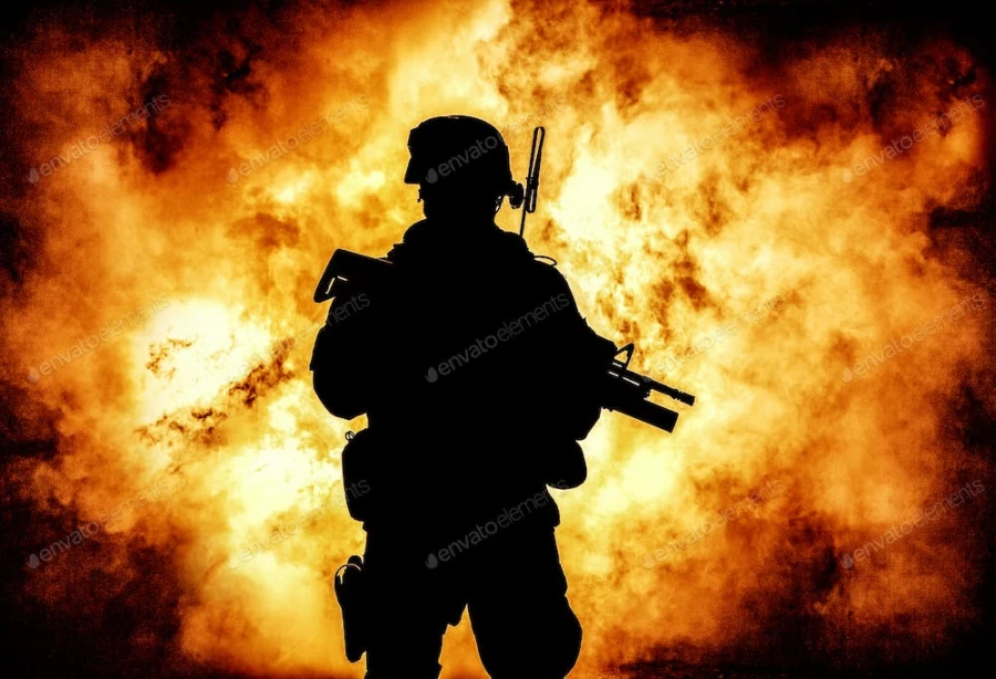 عکس استوک سایه ی سرباز با تفنگ در پس زمینه شعله ی آتش