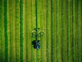 عکس تراکتور در حال حرکت در مزرعه سبز