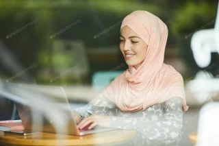 عکس خانم با روسری در حال کار با لپ تاپ